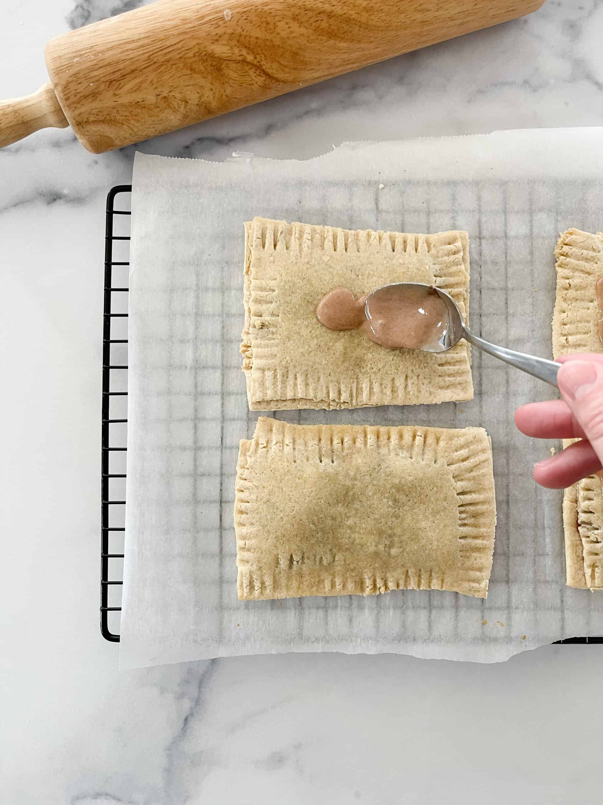 Adding the frosting on the cooked pop tart. 