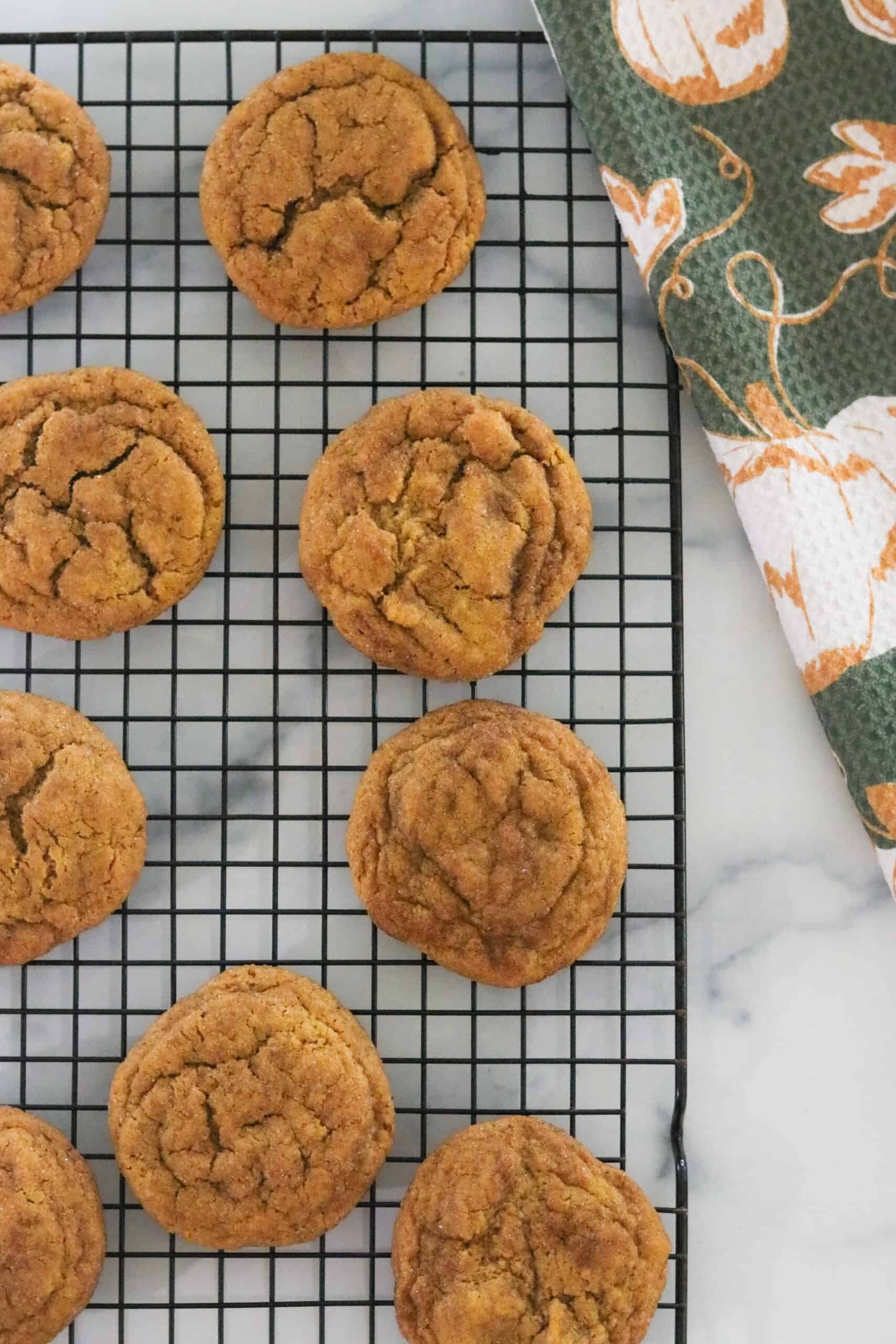 Pumpkin spice snickerdoodle cookies cooling on a rack. 