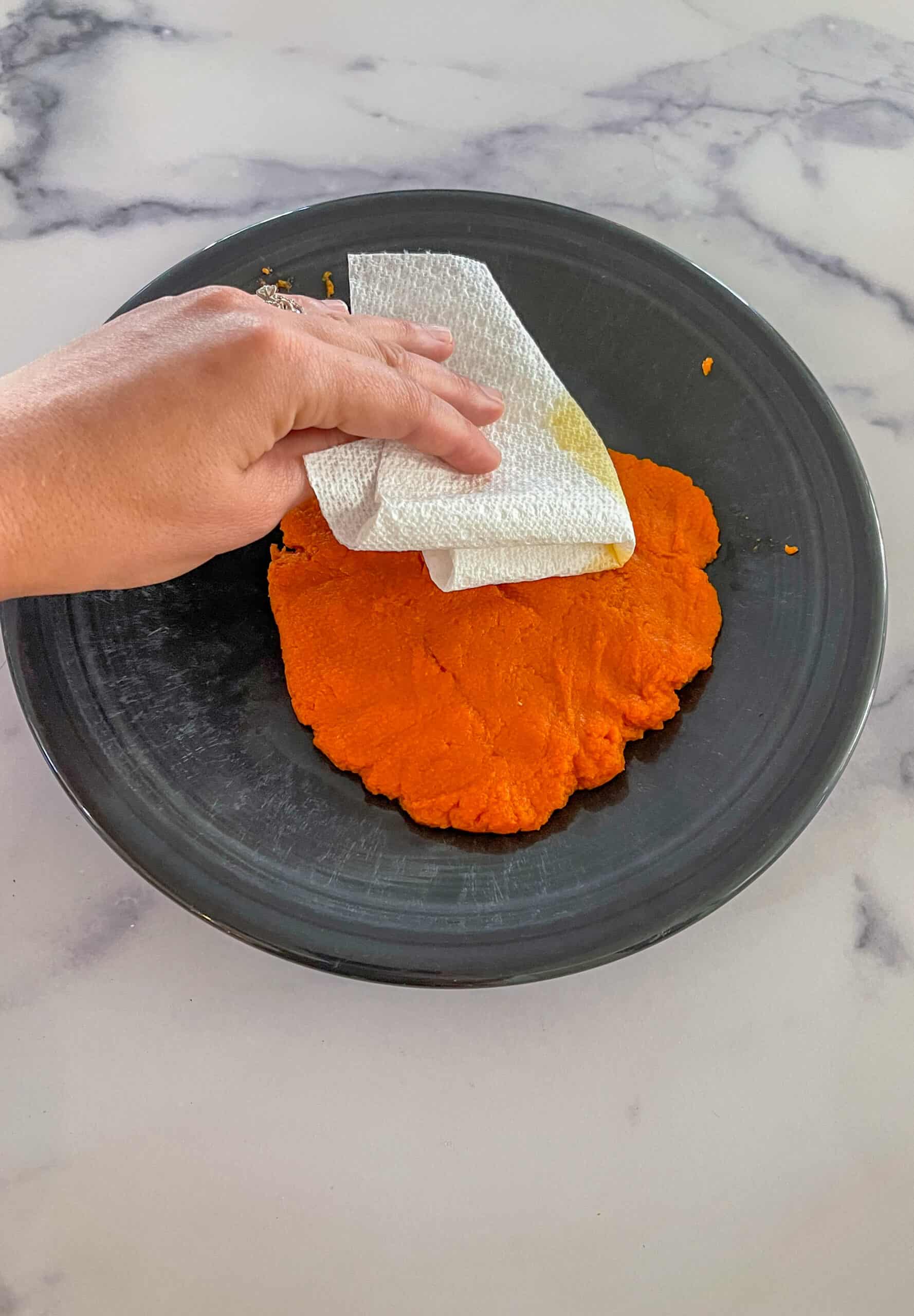 Patting pumpkin puree dry.